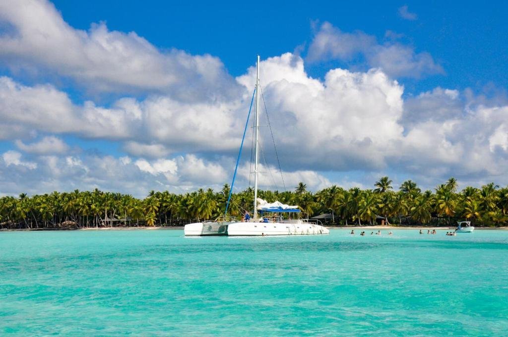 "Catamarán navegando hacia Isla Saona en el mar Caribe turquesa"